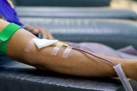 man as blood donor at donation with a bouncy ball holding in hand.の写真素材
