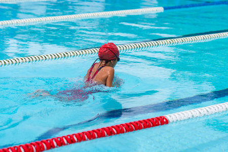 child swimmer swim in swimming pool. Water sports and competition, learning to swim classes for children.の写真素材
