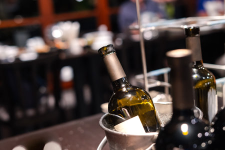 close-up of red wine bottle in ice bucket on romantic table, background out of focus.の写真素材