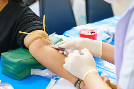 Close up hand collecting blood sample for diagnosis and treatment patient in the hospital.Laboratory technician taking blood for blood chemistry analysis.の写真素材