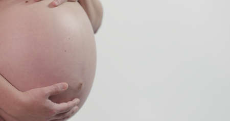 Full Term 40 Weeks 9 Month Pregnant Woman Bare Belly Close Up Skin Hands On White Isolated...