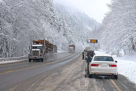 Winter Weather, Harsh Road Conditions, People Putting Chains on Vehicles, Snowy Mountain Passの写真素材