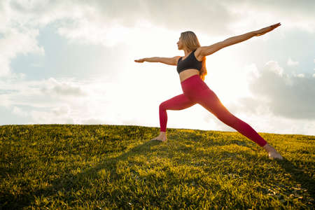 Beautiful Woman Yoga Exercise Pose Warrior 2 Asana Position Tranquil Sunset - Silhouette Isolated Backgroundの写真素材