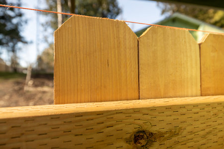 Close Up of String Spaced Along Top Portion of Wood Cedar Pickets on New Fence Build DIY Yard Improvementの写真素材