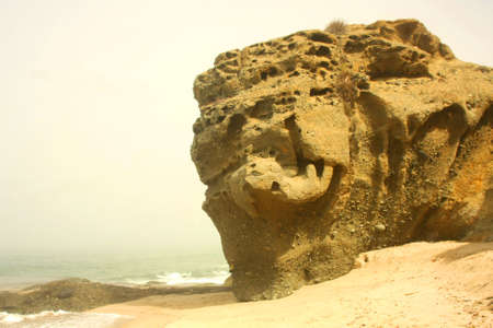 Huge Rock on the beach with fog rolling inの写真素材