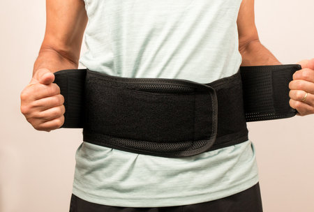 Senior Man wearing a black Back Brace for lower back support