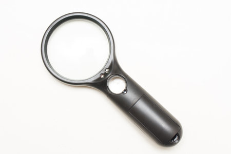 A black magnifying glass with an optical magnifier on a white backgroundの写真素材