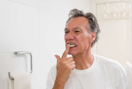 Man Examine his night guard in front of a mirrorの写真素材