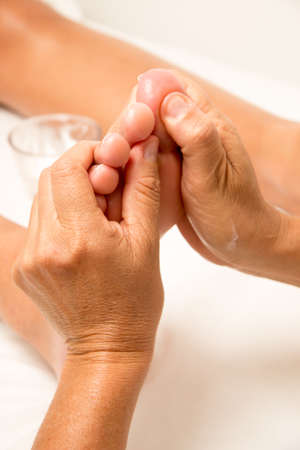 Massage Therapist Massaging a Womenâs Footの写真素材