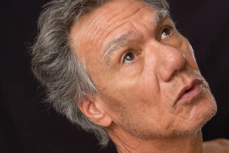 Distraught unshaven senior man at home looking depressed and tired of being locked downの写真素材