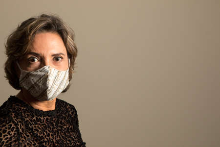 Woman Wearing a Protective Face Mask at Home to combat the spreading of virusの写真素材
