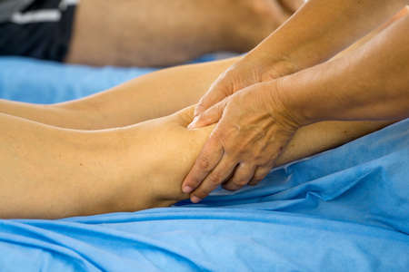 Massage Therapist Massaging a Womenâs Calf Muscleの写真素材