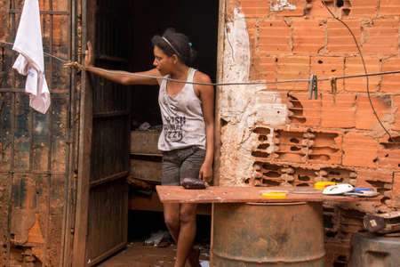 Planaltina, GoiÃ¡s, Brazil-April 28, 2018: A lyoung woman standing outside in front of her home in the impoverished community of Planaltina.のeditorial素材