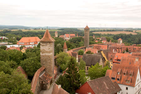 Rothenburg ob der tauber, Germany August 17, 2019: View of Part of the Stonewall and Towers that Surrounds the Medieval City of Rothenburg with Wind Turbines in the far backgroundのeditorial素材