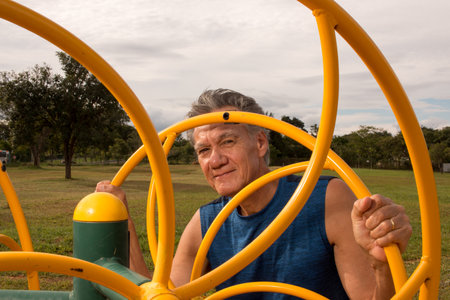 Senior Man working out at an outdoor fitness park in Parque Das GarÃ§as,  Brasilia