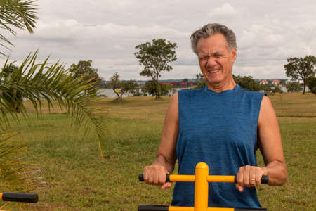 Senior Man working out at an outdoor fitness park in Parque Das GarÃ§as,  Brasilia