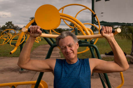 Senior Man working out at an outdoor fitness park in Parque Das GarÃ§as,  Brasilia