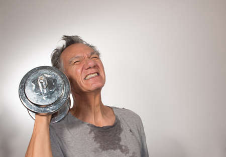 Fit Senior Man at Home Working out with Weights against a White Backgroundの写真素材