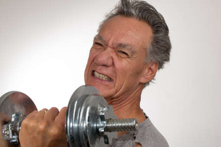 Fit Senior Man at Home Working out with Weights against a White Background
