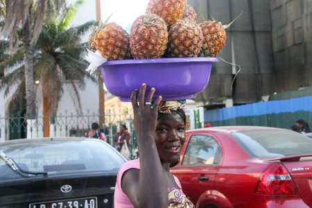 Luanda, Angola February 12, 2009; Impoverished Woman Street Vendor walking the streets of Luanda, selling Pineapplesのeditorial素材