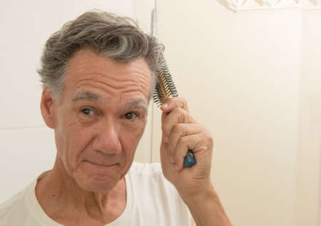 Mature Man Brushing an Combing his Hairの写真素材