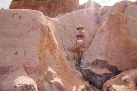Fit Woman standing at the Colorful Red Cliffs known as the Falesias near Arraial dâ€™ Ajuda,...