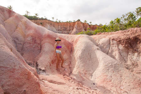 Fit Woman standing at the Colorful Red Cliffs known as the Falesias near Arraial dâ Ajuda, Bahia, Brazilの写真素材