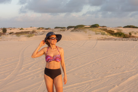 Lady in beach wear posing at the Sand Dunes Dunes near the small town of Combuco, Brazil, Cearaの写真素材