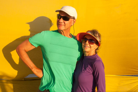 Couple standing against a yellow background in the late afternoonの写真素材