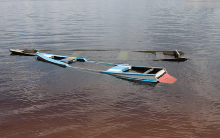 Small old wooden boats filled with water found on the shore of the Rio Negro River in Airao, Brazilの写真素材