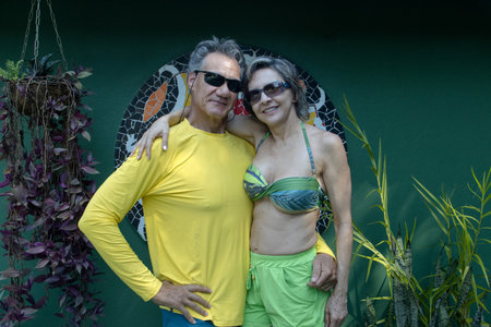 Mature Couple in colorful clothing hanging out at a garden embracing each otherの写真素材