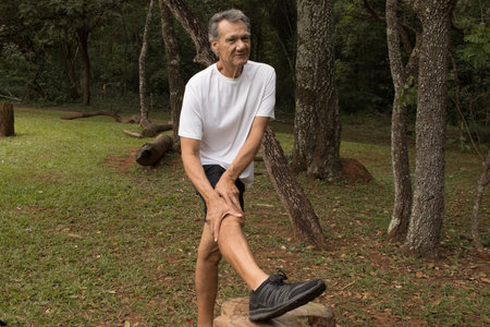 Mature Man outside at a local park doing Stretching his leg before working outの写真素材