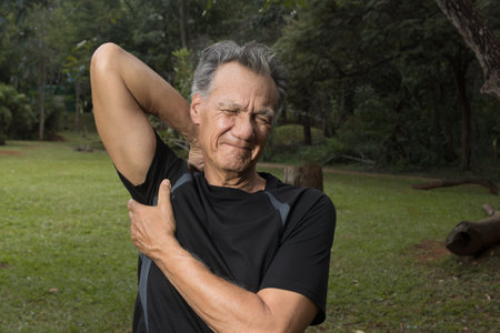 Mature Man outside at a local park doing Stretches before working outの写真素材