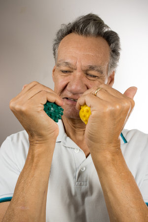 Mature man holding and squeezing massage therapy spike ballsの写真素材