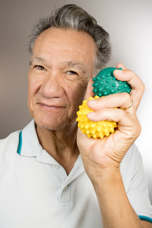 Mature man holding and squeezing massage therapy spike ballsの写真素材