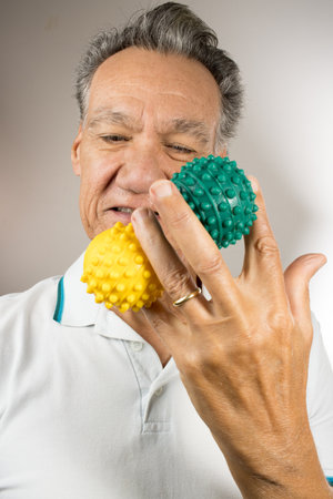 Mature man holding and squeezing massage therapy spike ballsの写真素材