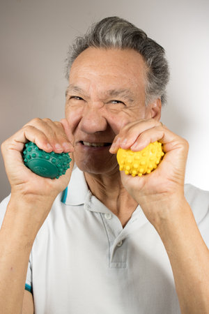 Mature man holding and squeezing massage therapy spike ballsの写真素材