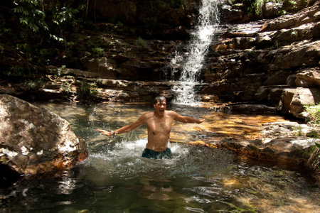 Man enjoying himself at one of the many waterfalls in Chapada Veadeirosの写真素材