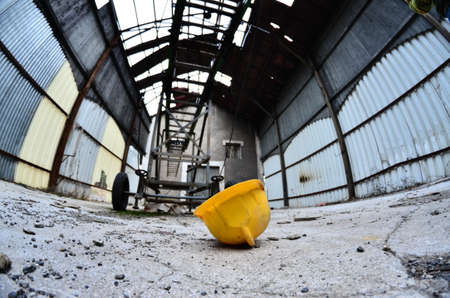 fish eye projection fo a yellow hard hat on the floor inside a barn at canfranc in spainの写真素材