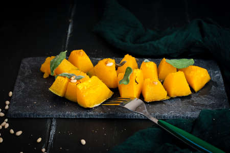 Oven baked pumpkin slices with salvia and pine nutsの写真素材