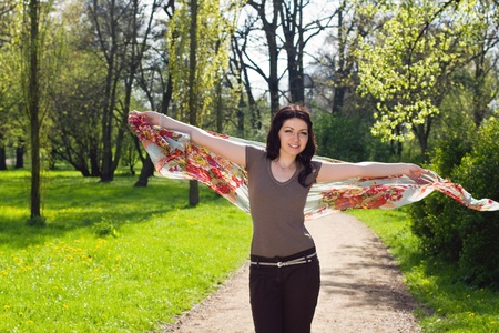 Pretty young brunette woman walking with flowered shawlの写真素材