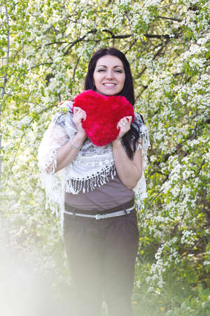 Happy young woman holding red heartの写真素材