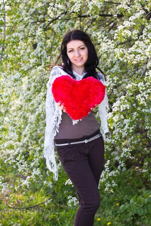 Happy young woman holding red heartの写真素材
