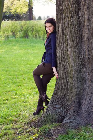 Beautiful young girl near tree in the parkの写真素材