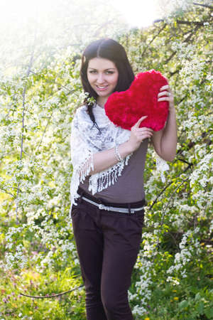 Happy young woman holding red heartの写真素材