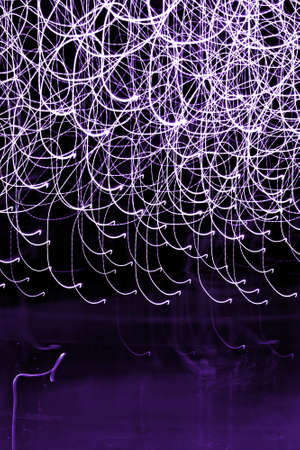 Abstract light trails background over blackの写真素材