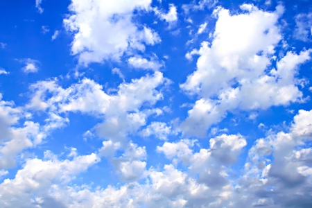 A horizontal shot of bright blue sky with white clouds