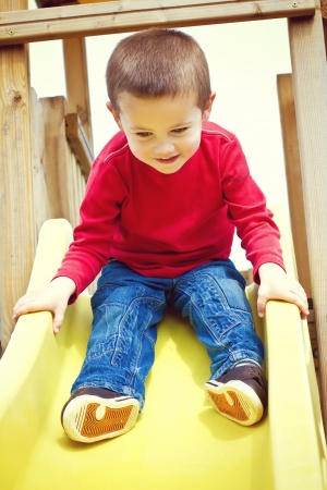 Little boy sliding on childrenの写真素材