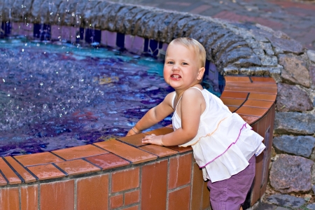 Little girl playing with water fountainの写真素材
