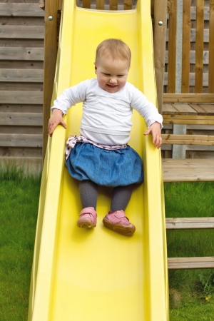 Little girl sliding on children's chuteの写真素材